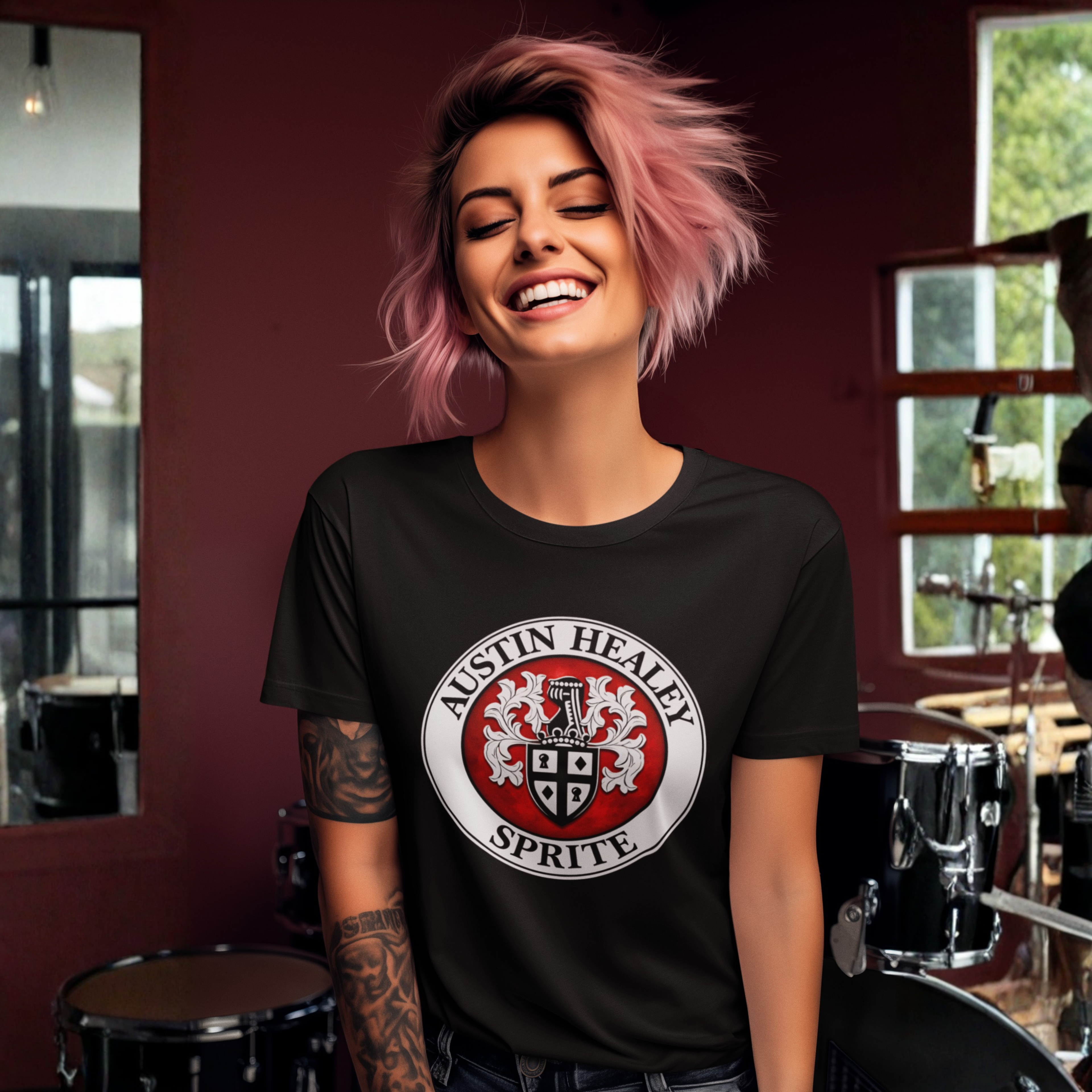 Woman wearing a black t-shirt with Austin Healey Sprite logo in a room with musical instruments.