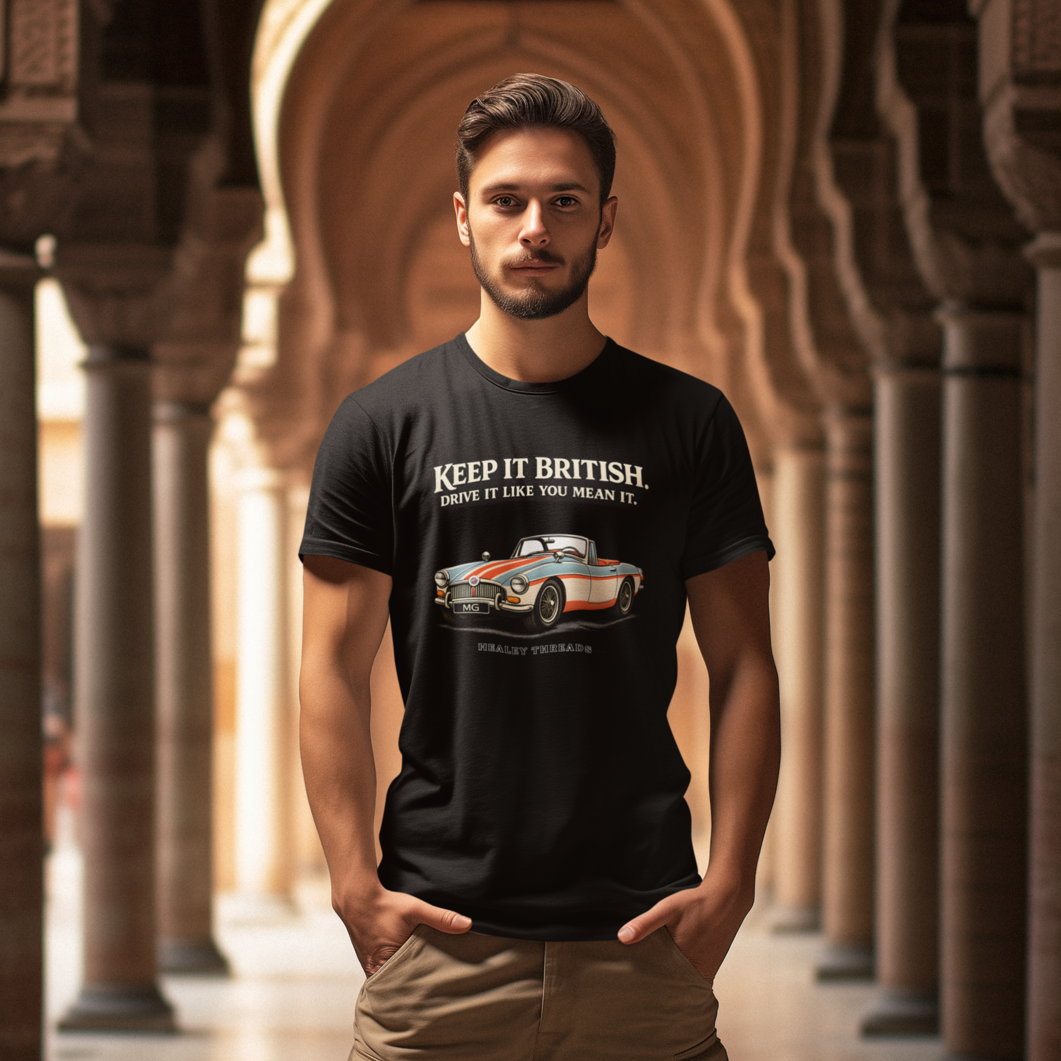 Man wearing a black t-shirt with a MGB car graphic and text in an architectural setting