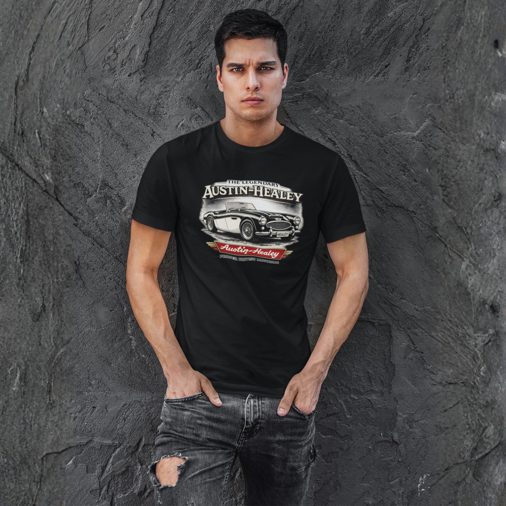 Man wearing a black t-shirt with Austin-Healey logo against a textured gray wall