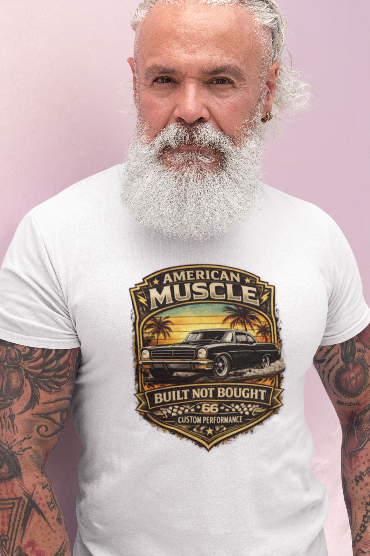 Man wearing a white t-shirt with a 'American Muscle' car graphic design on a pink background