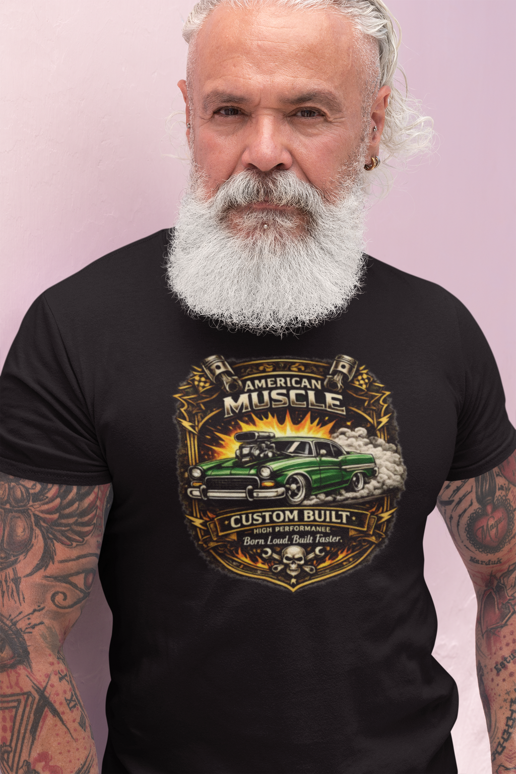 Man wearing a black t-shirt with a 'American Muscle' car graphic design on a light pink background