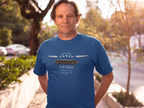 Man wearing a royal blue t-shirt with a vintage car design outdoors.