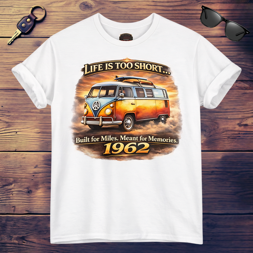 White t-shirt with vintage 1962 van graphic and text on a wooden surface with sunglasses and keychain.