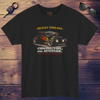 Black t-shirt with a graphic of a classic car and text on a wooden surface with sunglasses and a key.