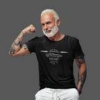 Man wearing a black t-shirt with a vintage car design, flexing his arm on a gray background