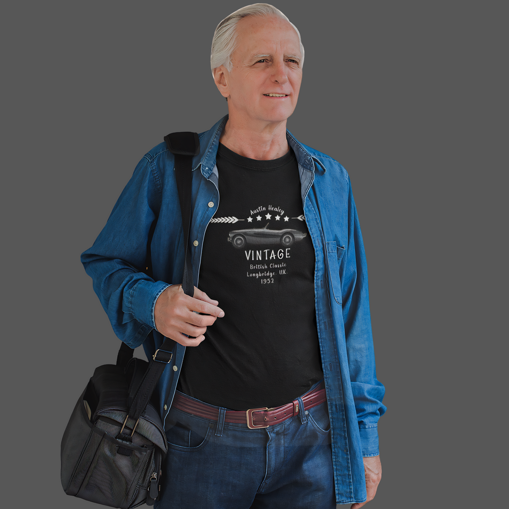 Man wearing a black t-shirt with vintage design and a blue jacket, holding a black bag on a gray background