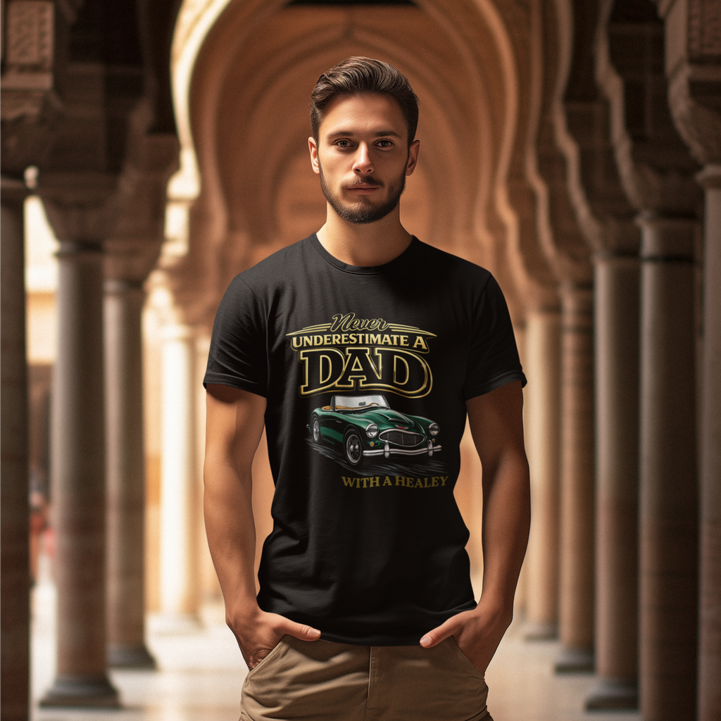 Man wearing a black t-shirt with a graphic classic car design and text, standing in an arched hallway.
