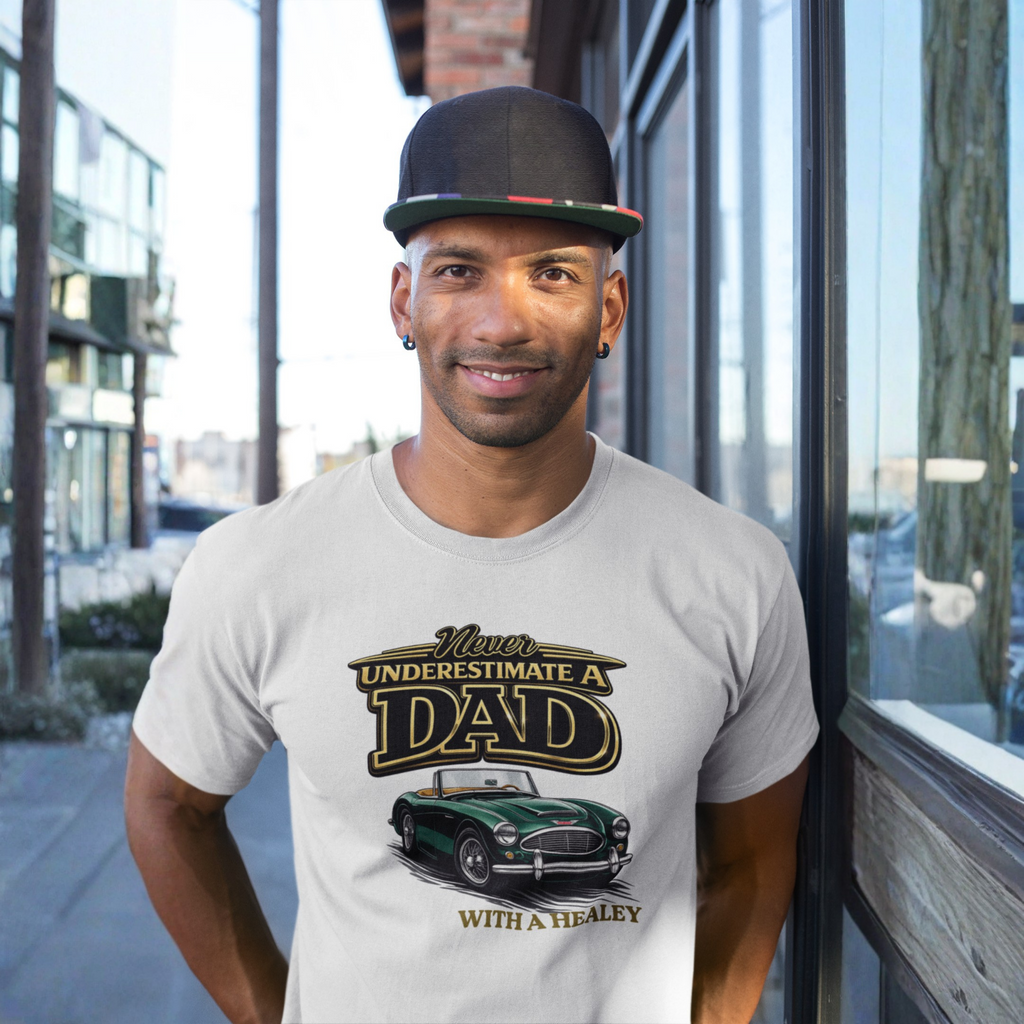 Man wearing a natural t-shirt with a classic car graphic and text, standing outdoors.