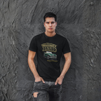 Man wearing a black t-shirt with a classic car graphic design against a textured gray wall