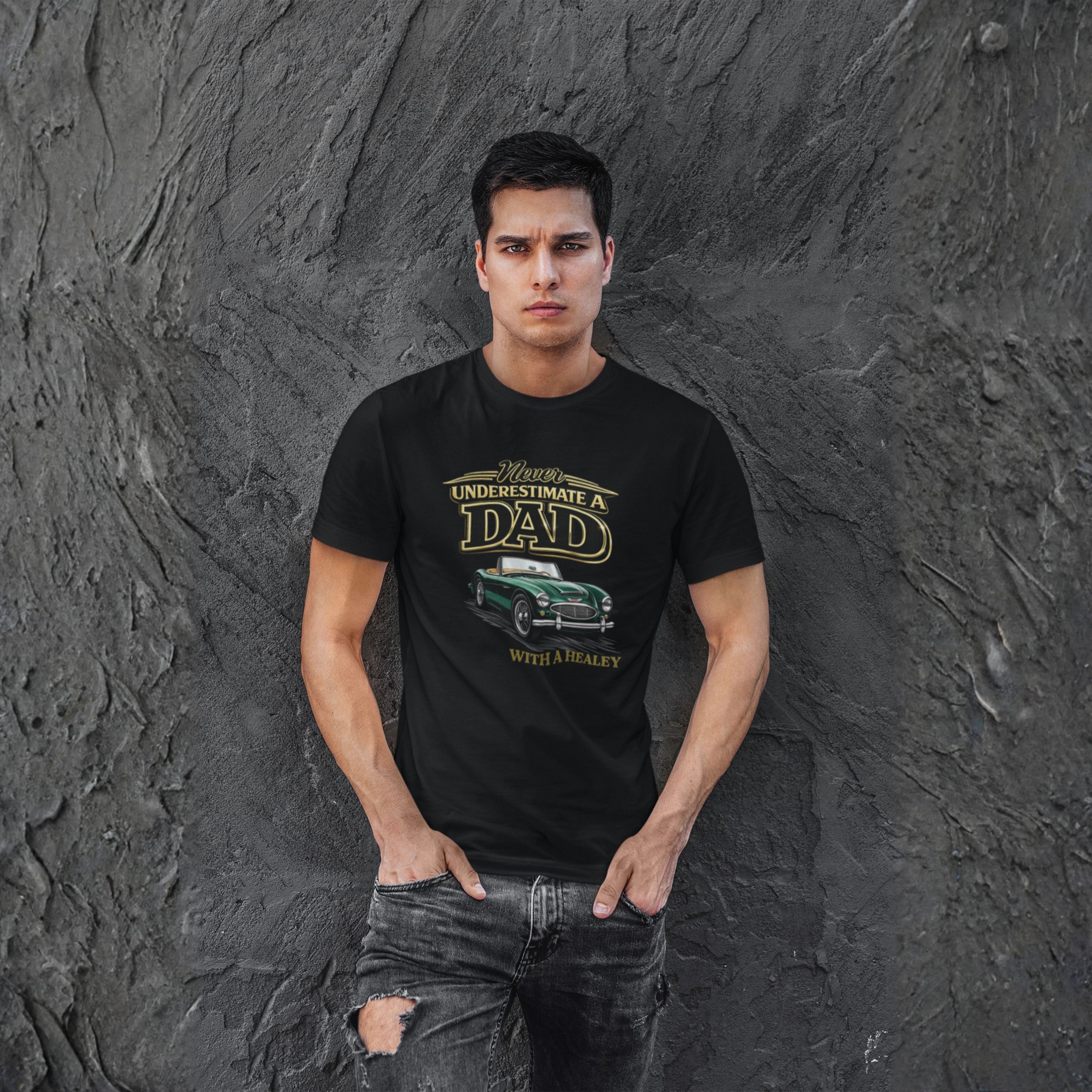 Man wearing a black t-shirt with a classic car graphic design against a textured gray wall