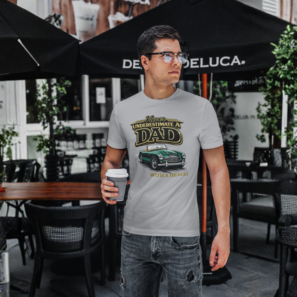 Man wearing a sport gray t-shirt with a classic car graphic design in an outdoor cafe setting