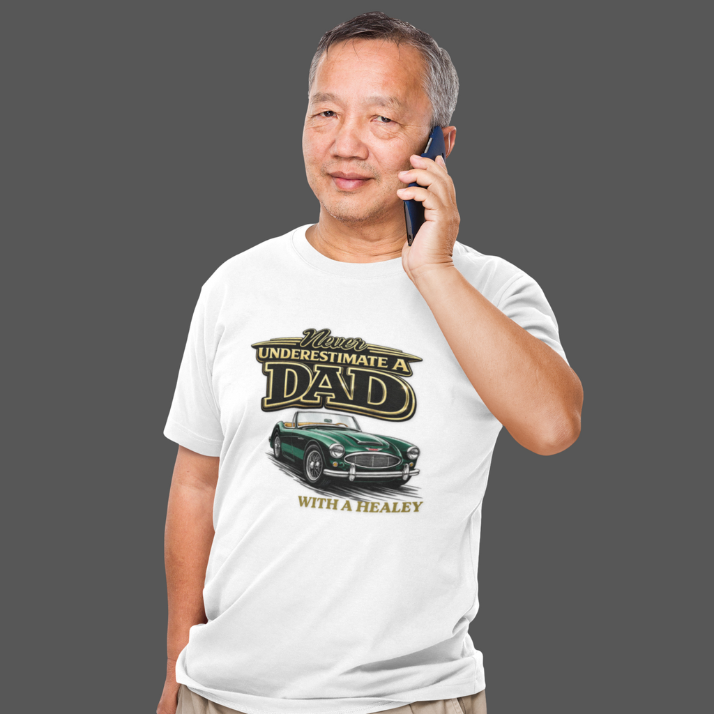 Man wearing a white t-shirt with a classic car graphic design and text, talking on a phone.