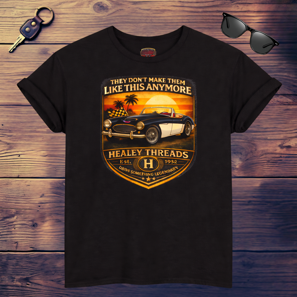 Black t-shirt with vintage car graphic and 'Healey Threads' text on a wooden surface.