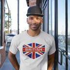 Man wearing a white t-shirt with a British flag design standing outside a building.