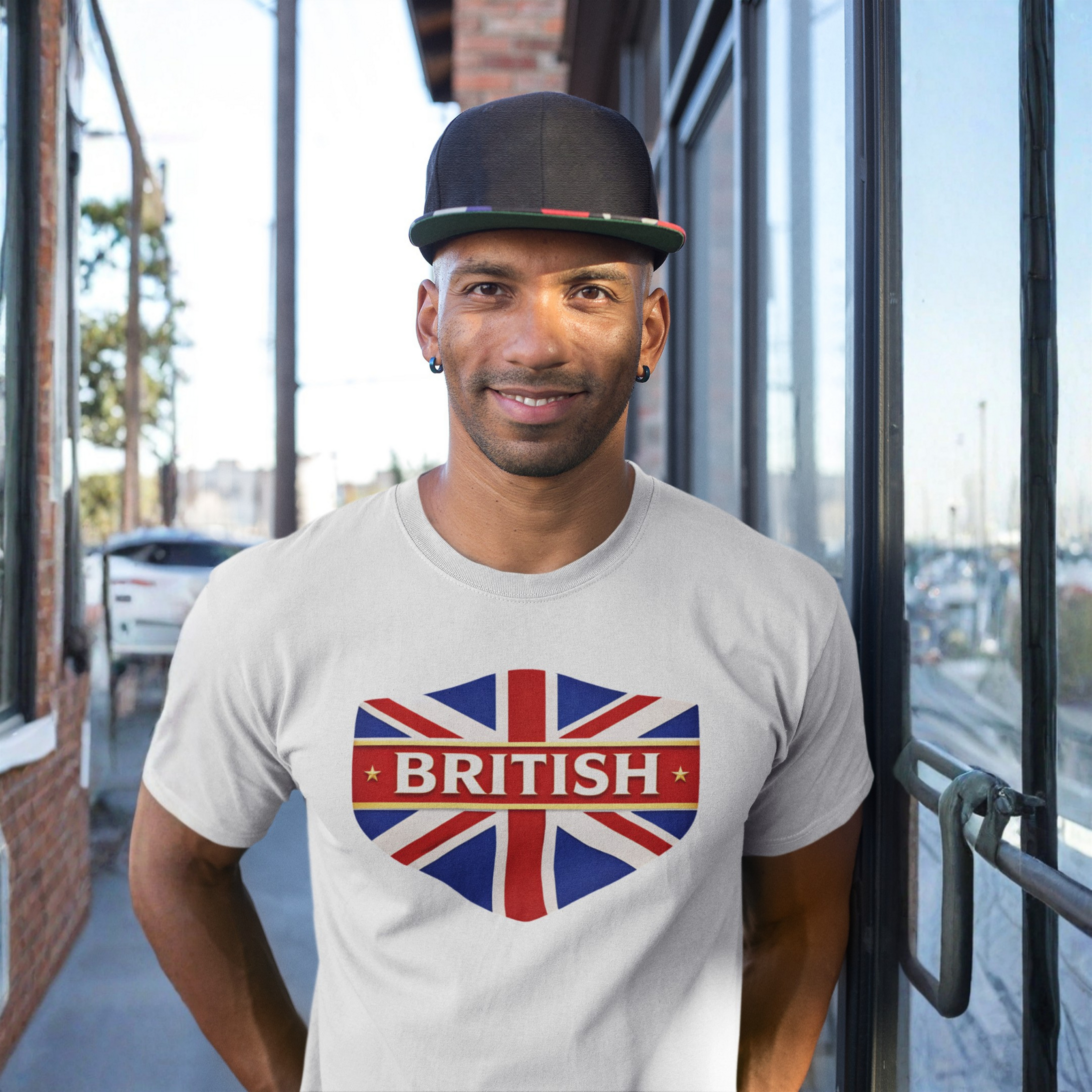 Man wearing a white t-shirt with a British flag design standing outside a building.