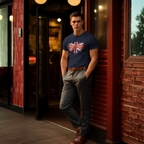 Man wearing a navy blue t-shirt with a British flag design, leaning against a brick wall.