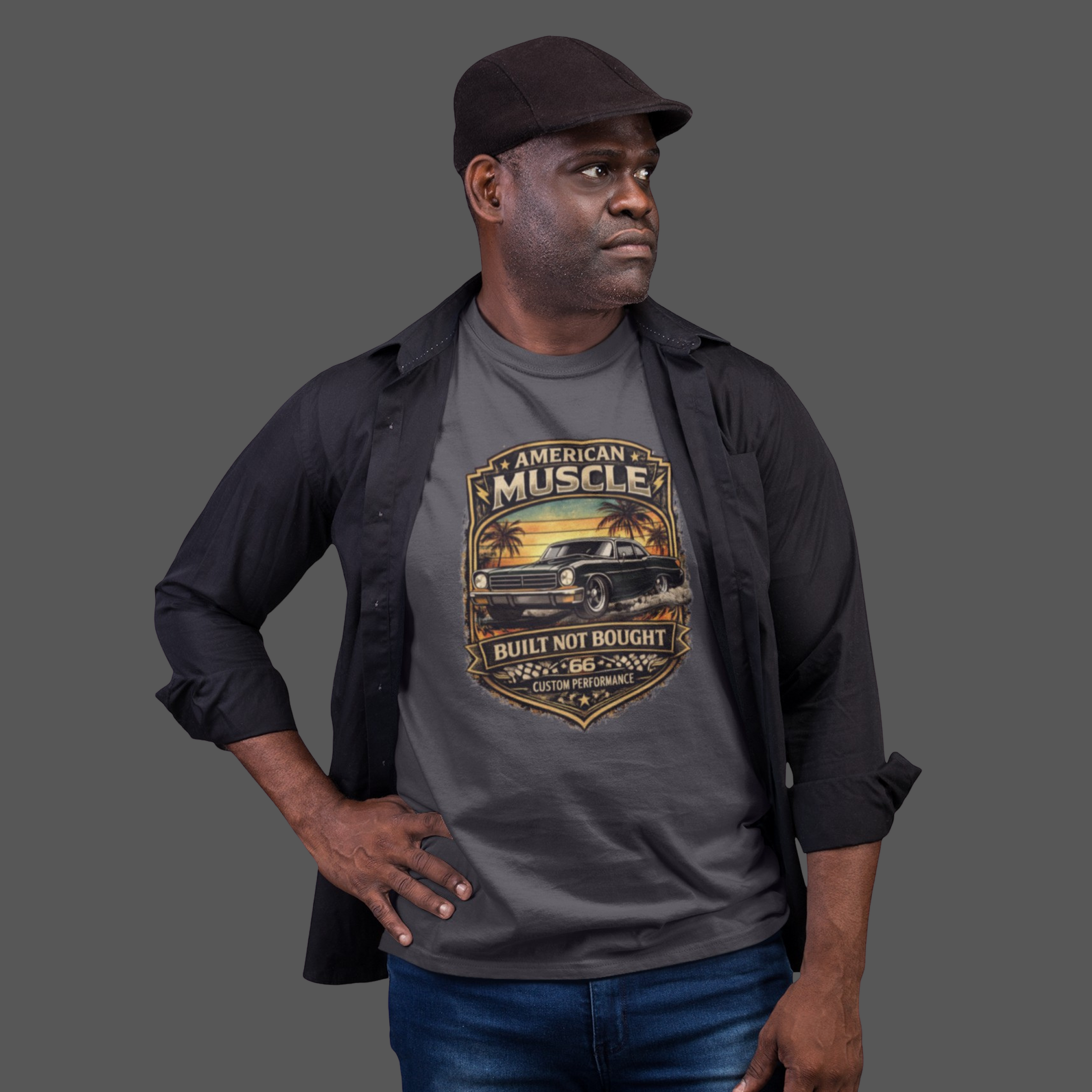 Man wearing a gray t-shirt with 'American Muscle' car graphic design on a plain background
