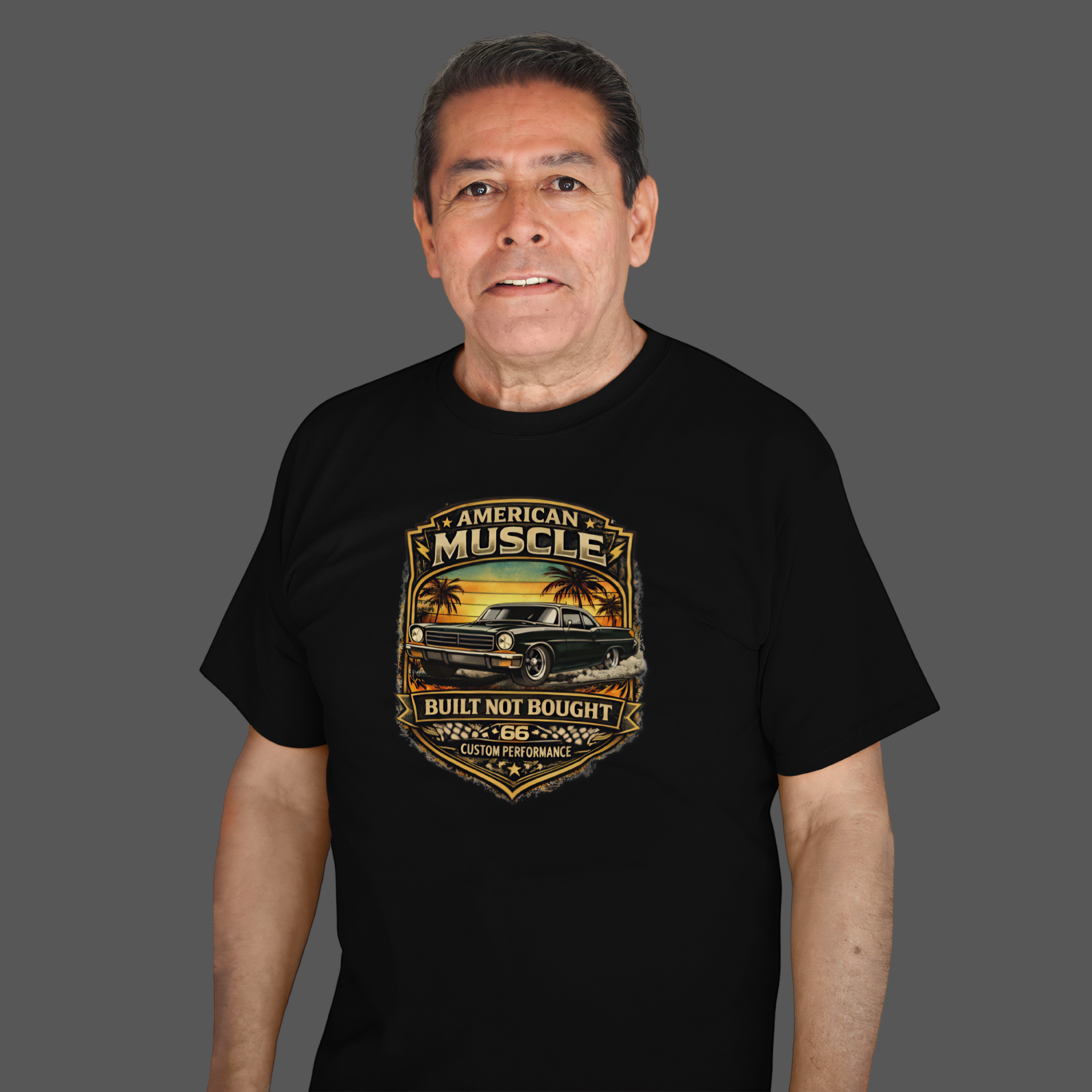Man wearing a black t-shirt with 'American Muscle' car graphic design on a gray background
