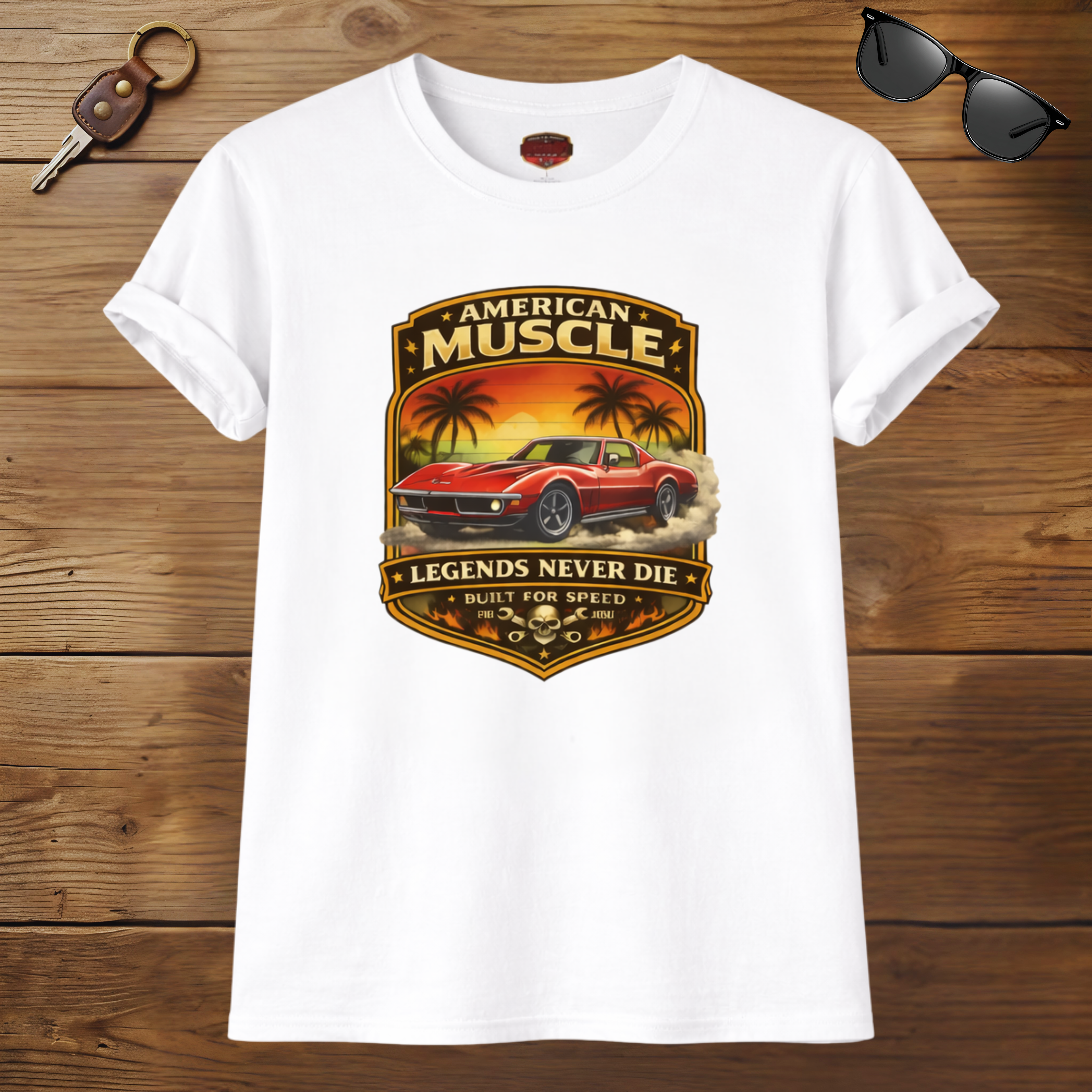 White t-shirt with American Muscle graphic design on a wooden surface with sunglasses and keychain.