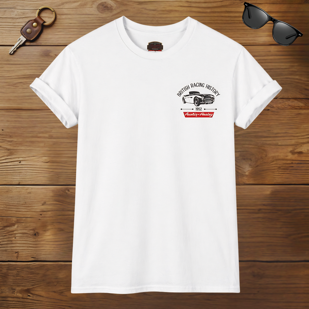 White t-shirt with a graphic Healey design on a wooden surface with sunglasses and keys.