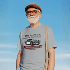 Man wearing a gray t-shirt with a graphic Healey car design against a blue sky.