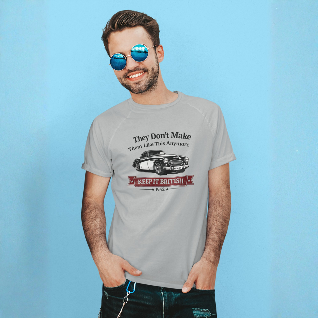 Man wearing a gray t-shirt with a Healey graphic car design on a blue background