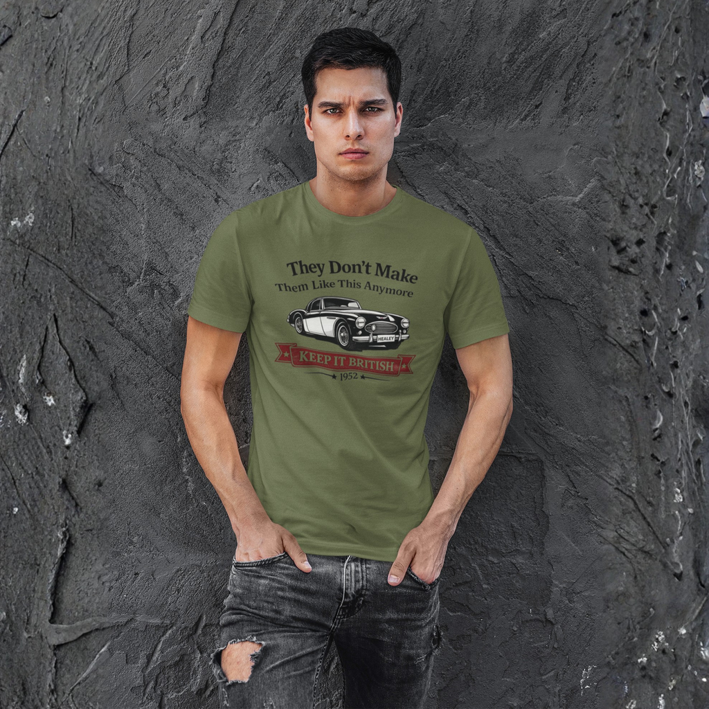 Man wearing a military green t-shirt with a graphic car design against a textured gray wall