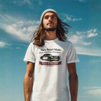Man wearing a white t-shirt with a graphic Healey car design against a blue sky.