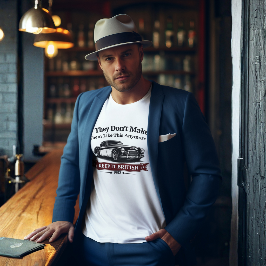 Man wearing a white t-shirt with a graphic Healey design, standing in a bar setting.