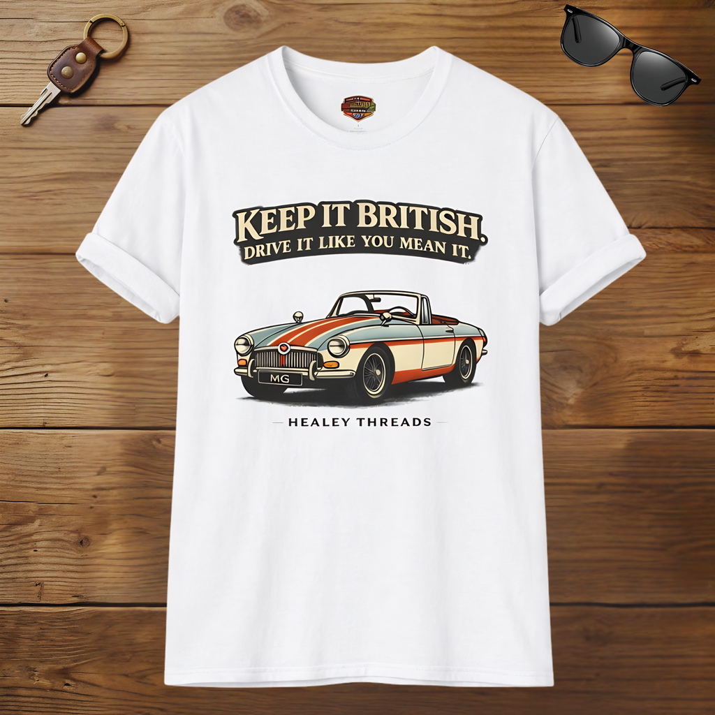 White t-shirt with MG car graphic and text on a wooden surface, accompanied by sunglasses and a key.