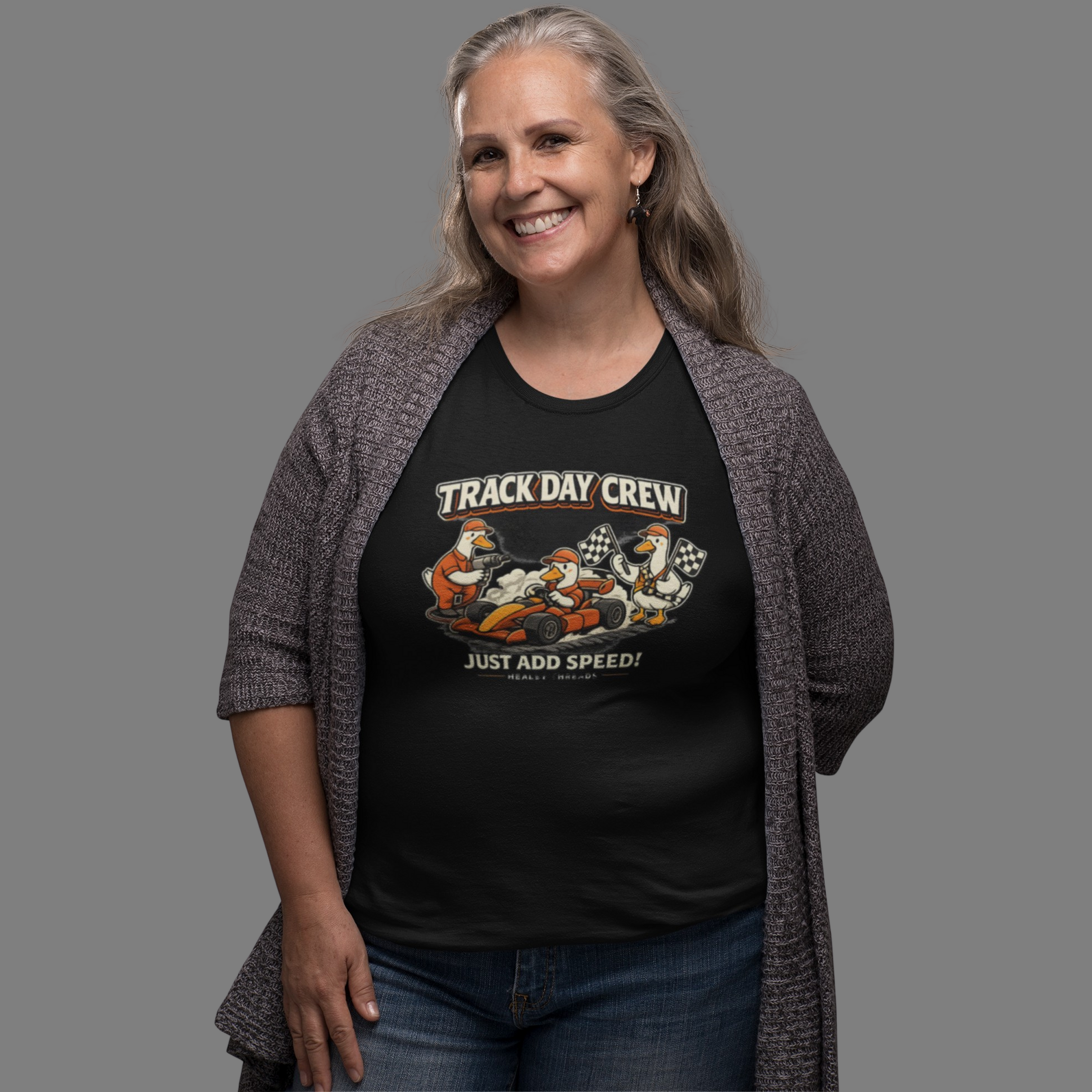 Woman wearing a black t-shirt with 'Track Day Crew' graphic design on a gray background