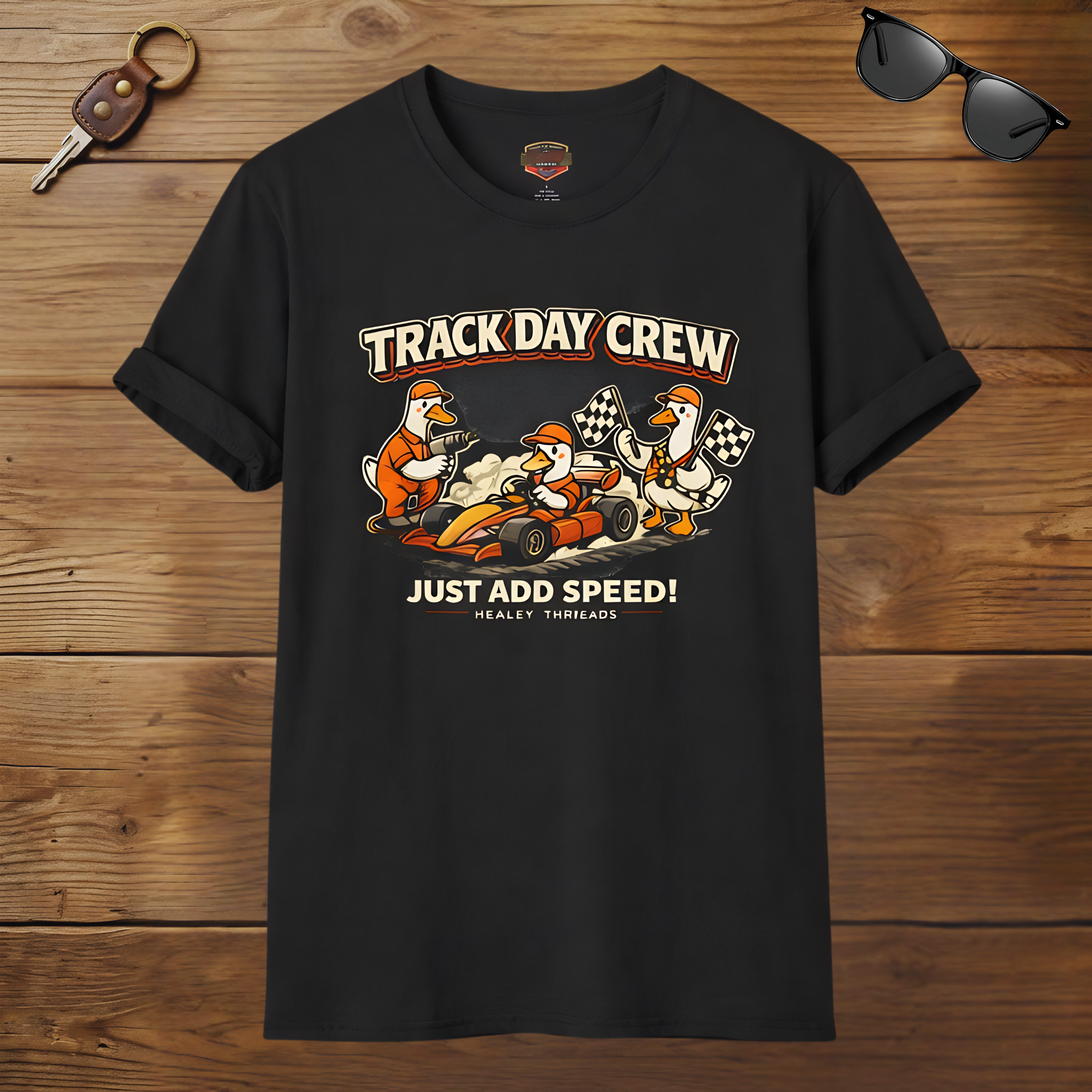 Black t-shirt with 'Track Day Crew' graphic on a wooden surface with sunglasses and keys.