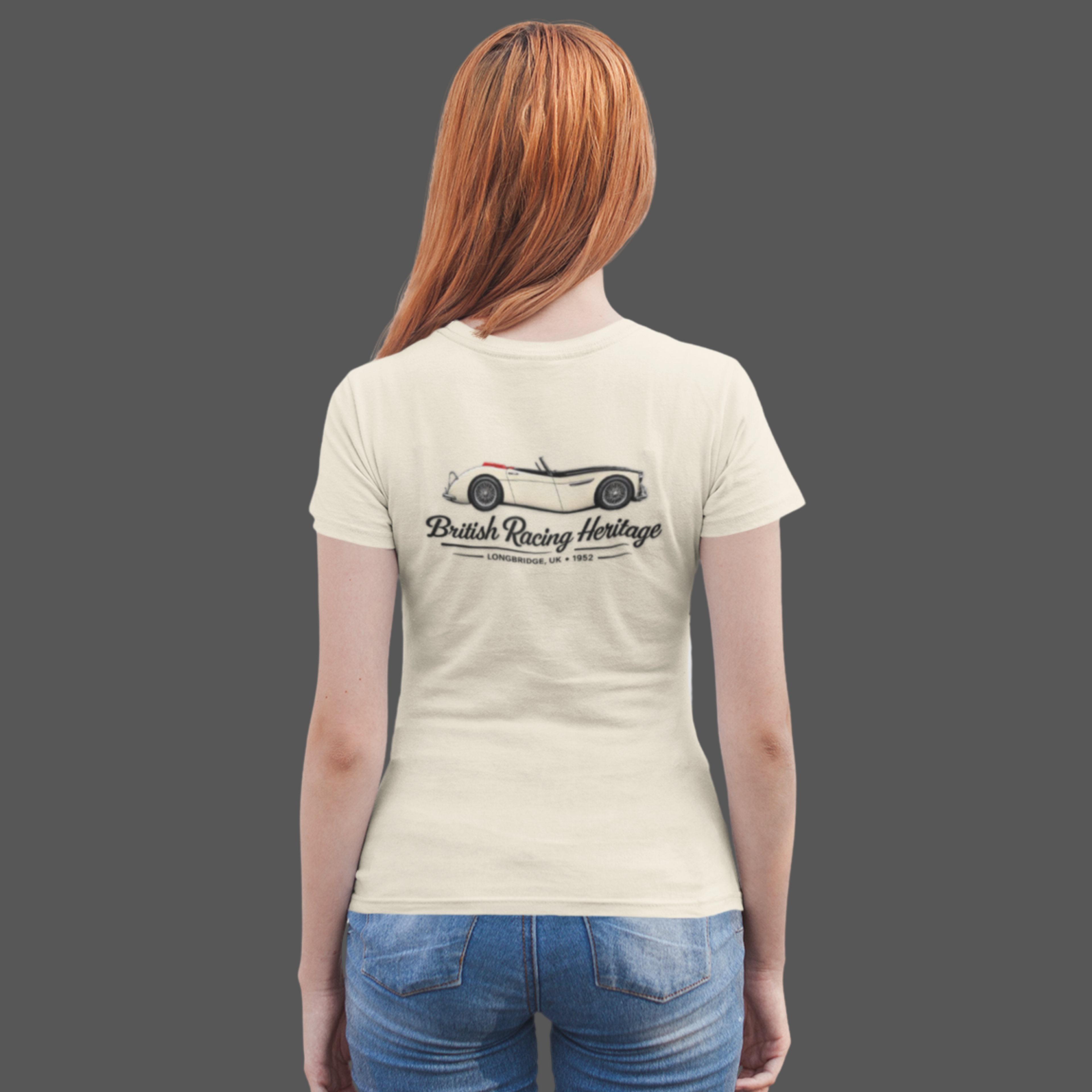 Back of a girl wearing a natural t-shirt with a Healey classic car graphic design on a gray background