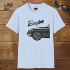 Light blue t-shirt with classic car graphic and text 'Built in Abingdon' on a wooden surface with sunglasses and keys.