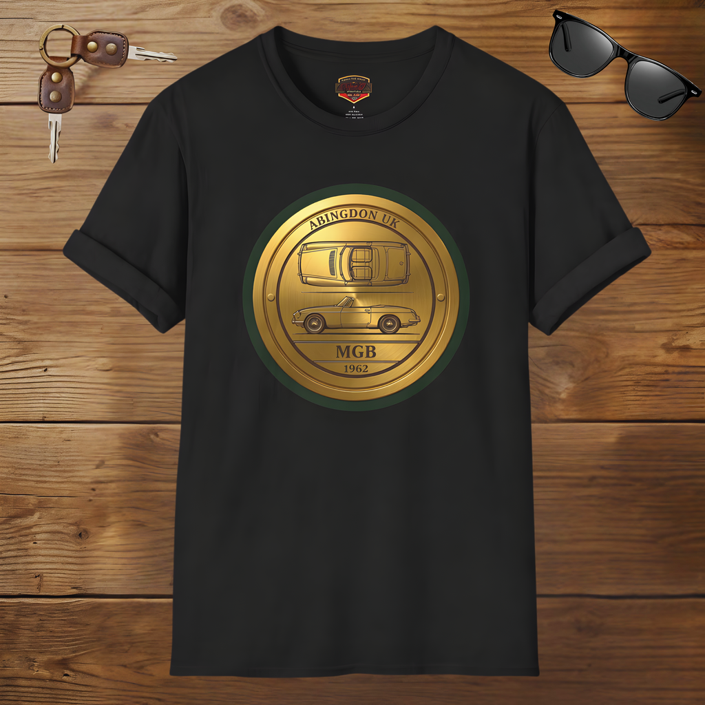 Black t-shirt with a gold classic car emblem on a wooden surface with sunglasses and keys.