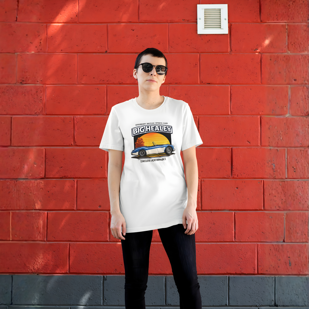 Woman wearing a Big Healey graphic white colored t-shirt featuring a blue and white Austin Healey roadster with retro sunset artwork and vintage British sports car, against a red wall