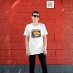 Woman wearing a Big Healey graphic white colored t-shirt featuring a blue and white Austin Healey roadster with retro sunset artwork and vintage British sports car, against a red wall