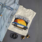 Folded Big Healey graphic natural colored t-shirt featuring a blue and white Austin Healey roadster with retro sunset artwork and vintage British sports car on a gray background