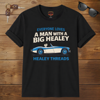 Black t-shirt with car graphic and text on a wooden surface