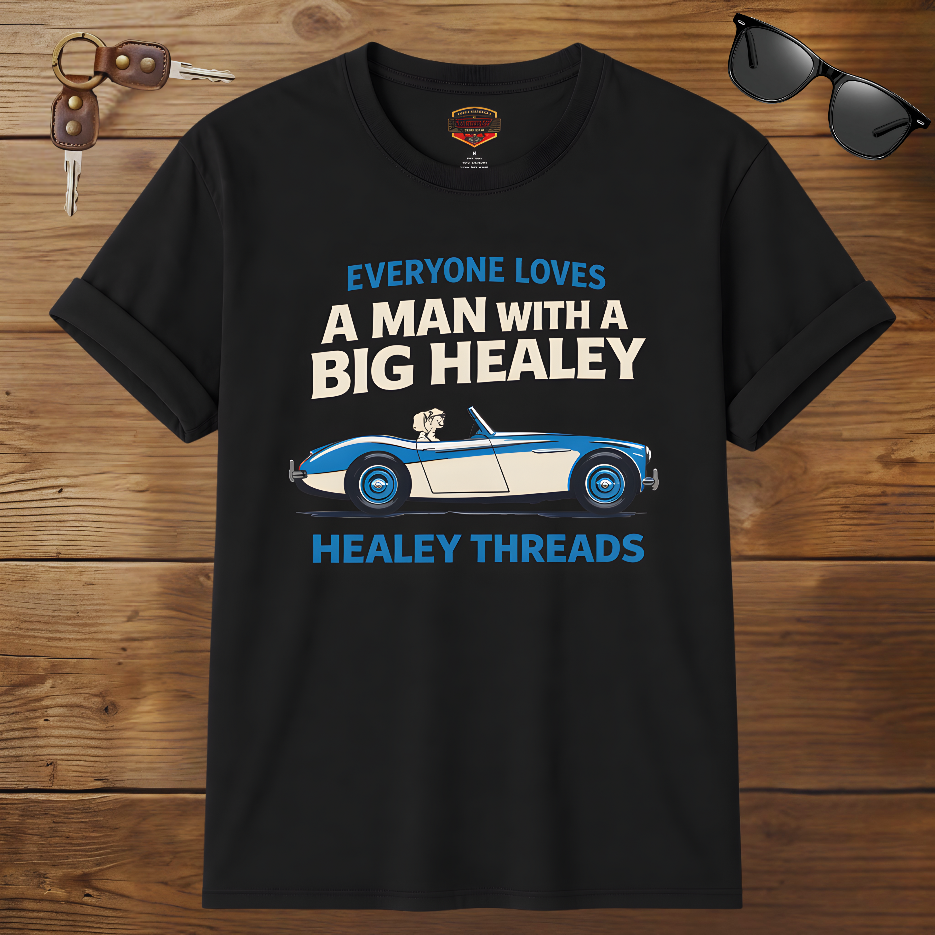 Black t-shirt with car graphic and text on a wooden surface