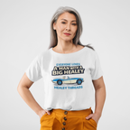 Woman wearing a white t-shirt with a Healey graphic and text, standing against a plain background