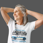 Woman wearing a white t-shirt with a Healey graphic and text, standing against a gray background