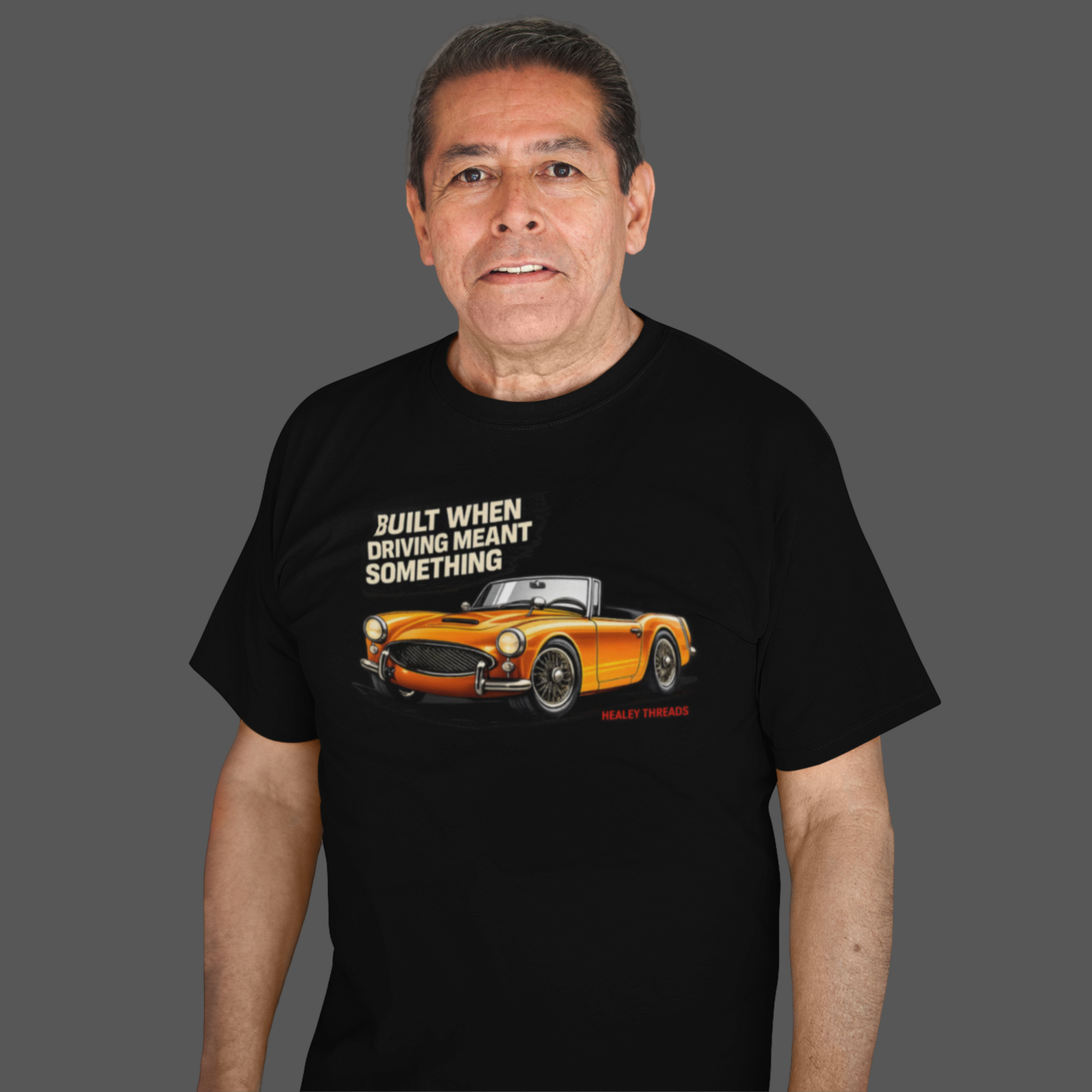 Man wearing a black t-shirt with a graphic of a car and text on a gray background