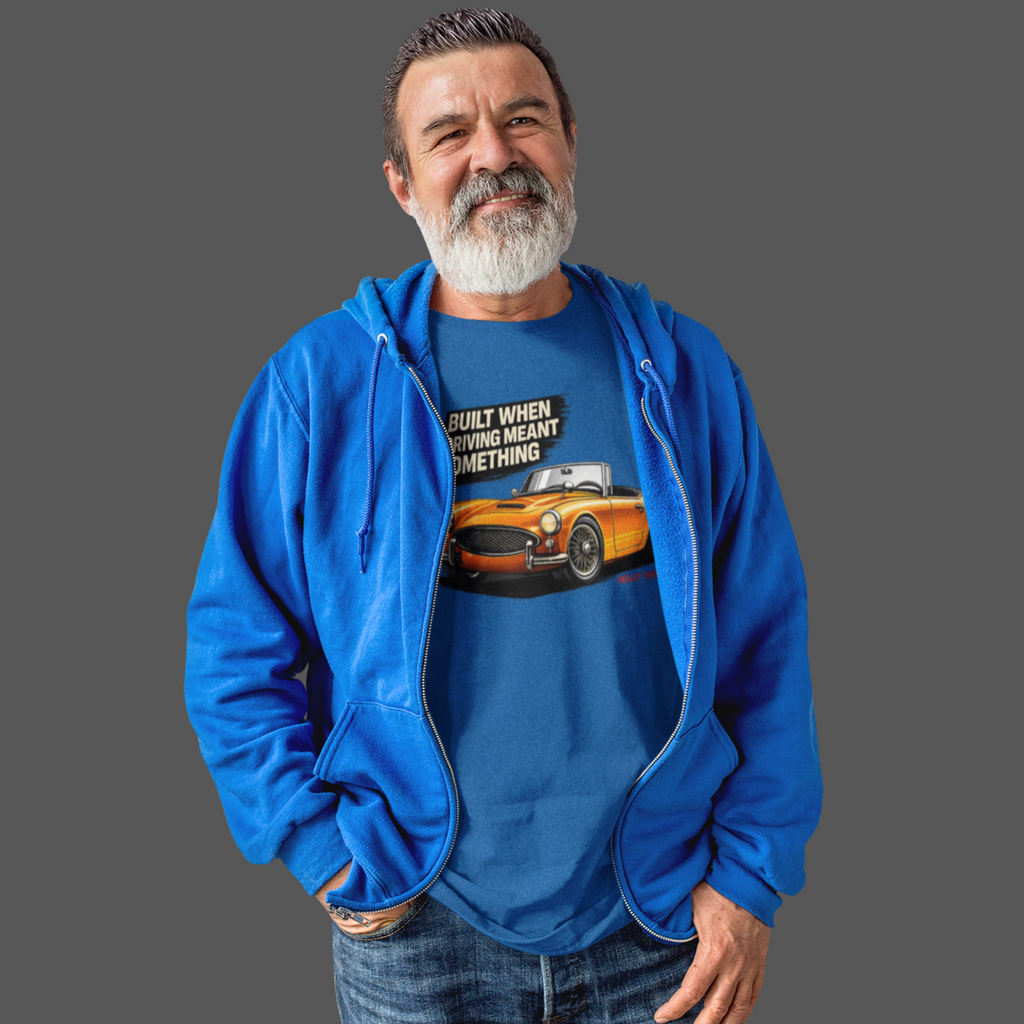 Man wearing a royal blue hoodie and graphic t-shirt with a car design on a gray background