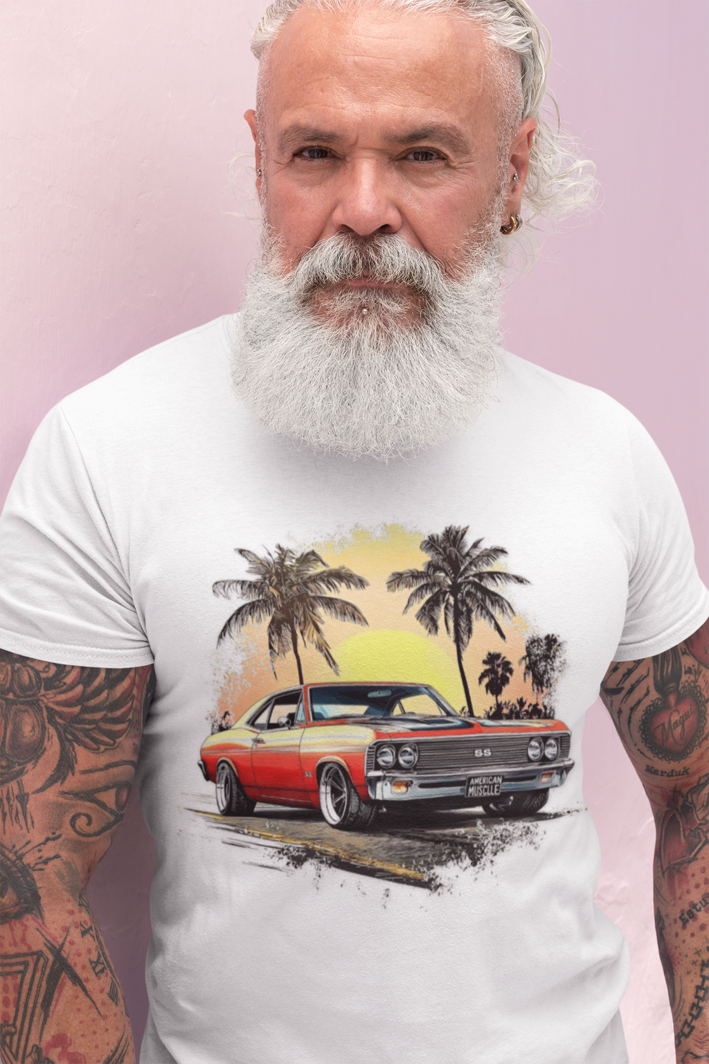 Man wearing a white t-shirt with a graphic of a classic car and palm trees on a pink background