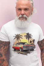 Man wearing a white t-shirt with a graphic of a classic car and palm trees on a pink background