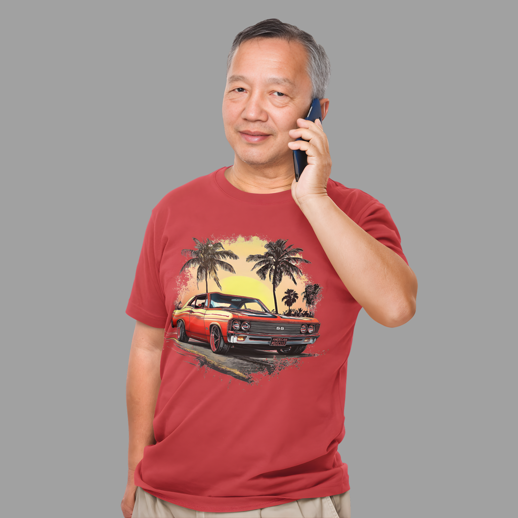 Man wearing a red t-shirt with a classic car and palm tree design, talking on a phone against a gray background