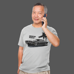 Man wearing a gray t-shirt with 'American Muscle' graphic and phone to ear on gray background