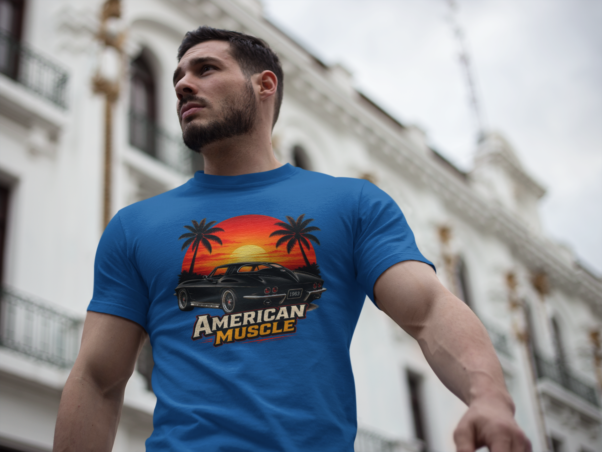 Man wearing a  royal blue t-shirt with 'American Muscle' graphic design in an urban setting