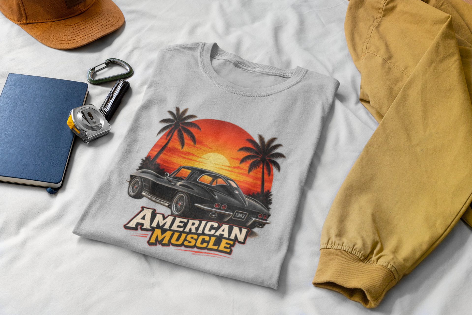 Gray t-shirt with 'American Muscle' graphic design on a white surface with accessories.